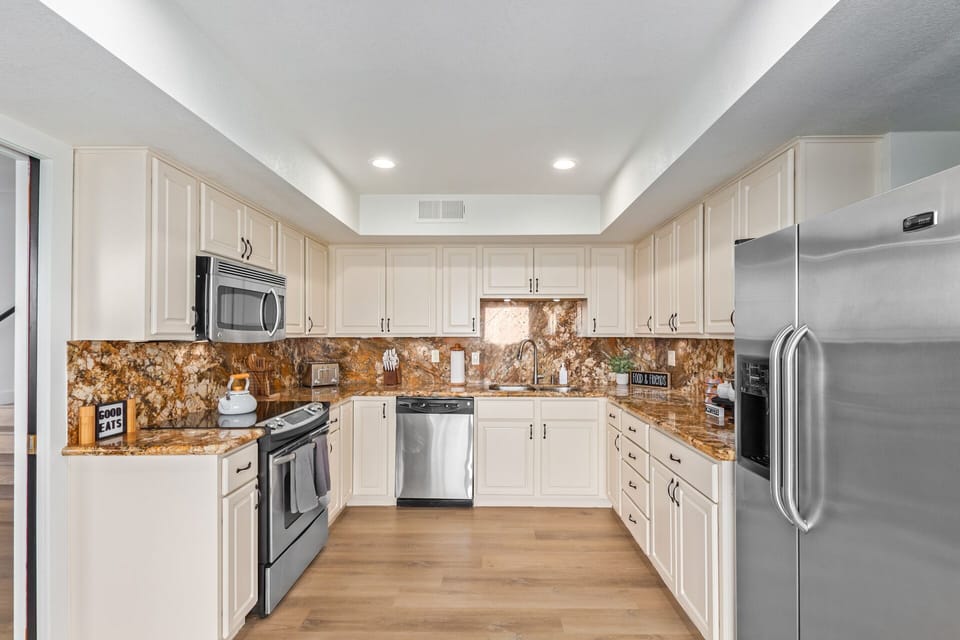 Beautiful kitchen with stainless steel appliances and cooking essentials. 