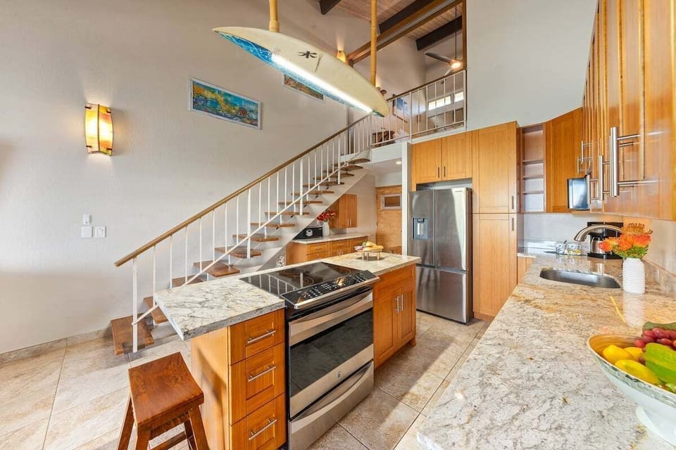 Remodeled kitchen with stainless appliances, generous storage, and bar seating.