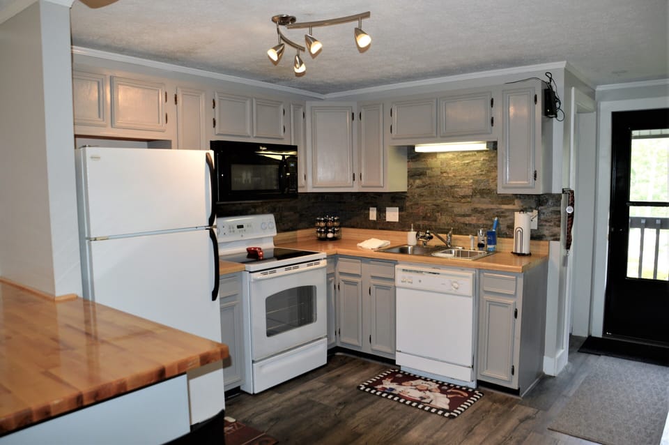 Beautiful full kitchen with refrig, over/stove, dishwasher, pots/pans, utensils