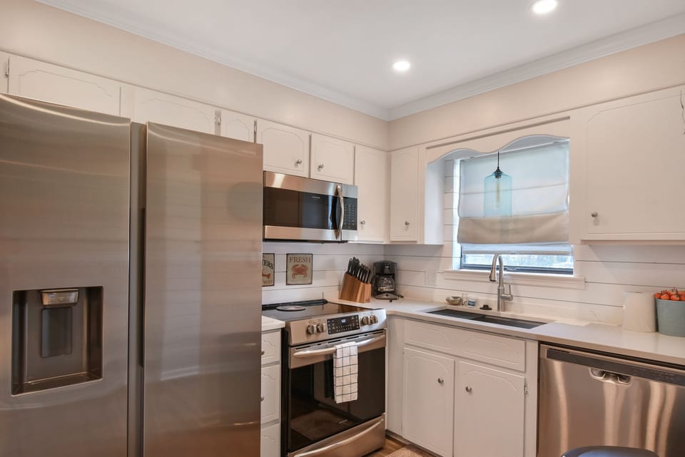 Stainless Kitchen with Modern Appliances - The fully stocked kitchen at Courtyard Villas E-5 includes stainless steel appliances, an oversized fridge, and plenty of prep space. Whether you’re cooking dinner or just chilling drinks, this St. Simons condo has you covered.