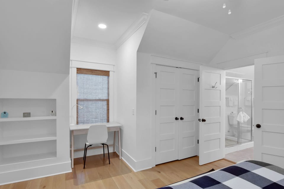 Upstairs King Suite – Desk, Built-Ins & En-Suite Bath Access - A second look at the upstairs king suite, featuring built-in shelving, a bright work desk, and direct access to a private en-suite bathroom. Thoughtful design for longer stays or quiet mornings with a laptop.