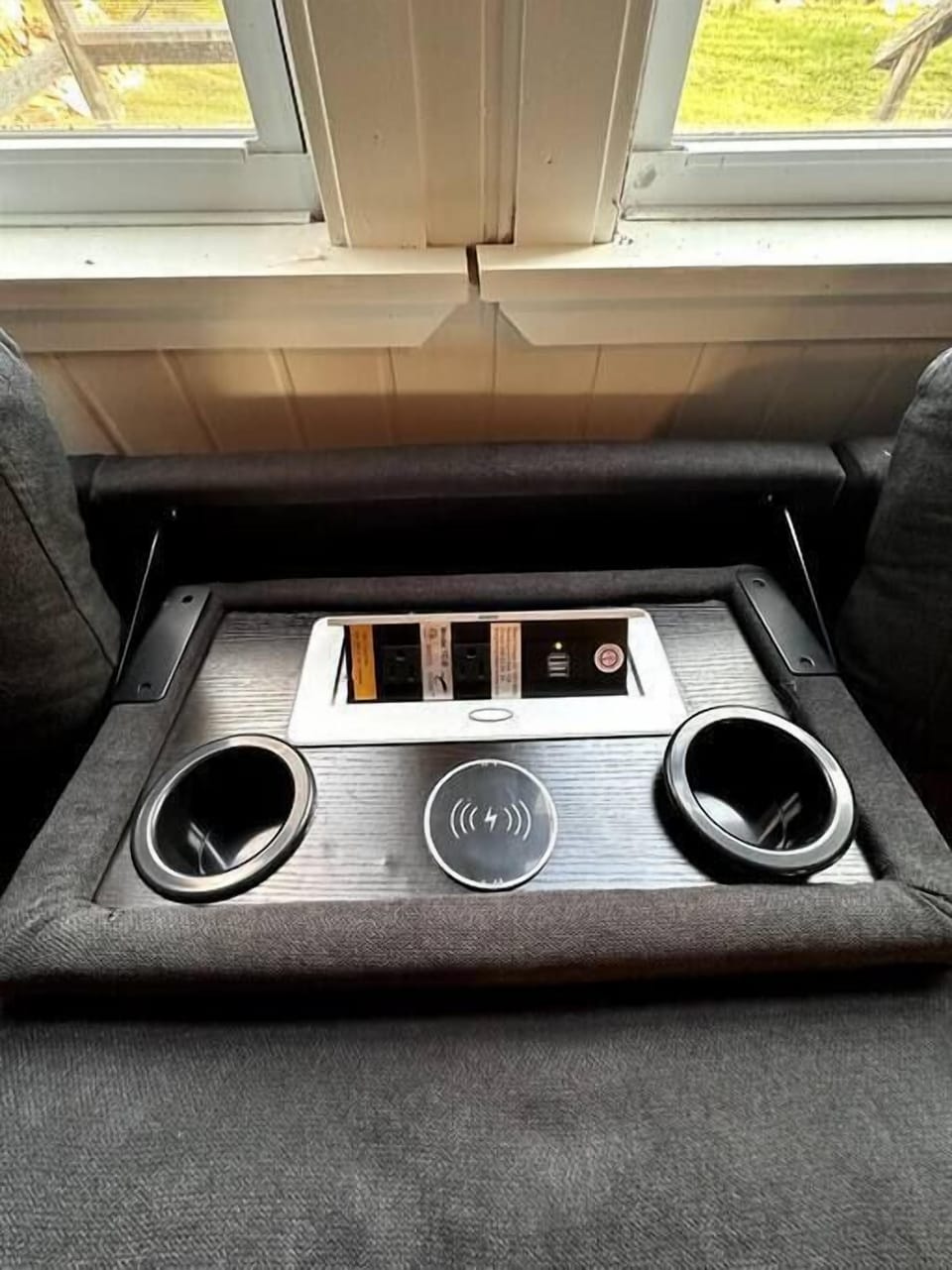 Charging port and cup holders in the couch! Even has a wireless charger!