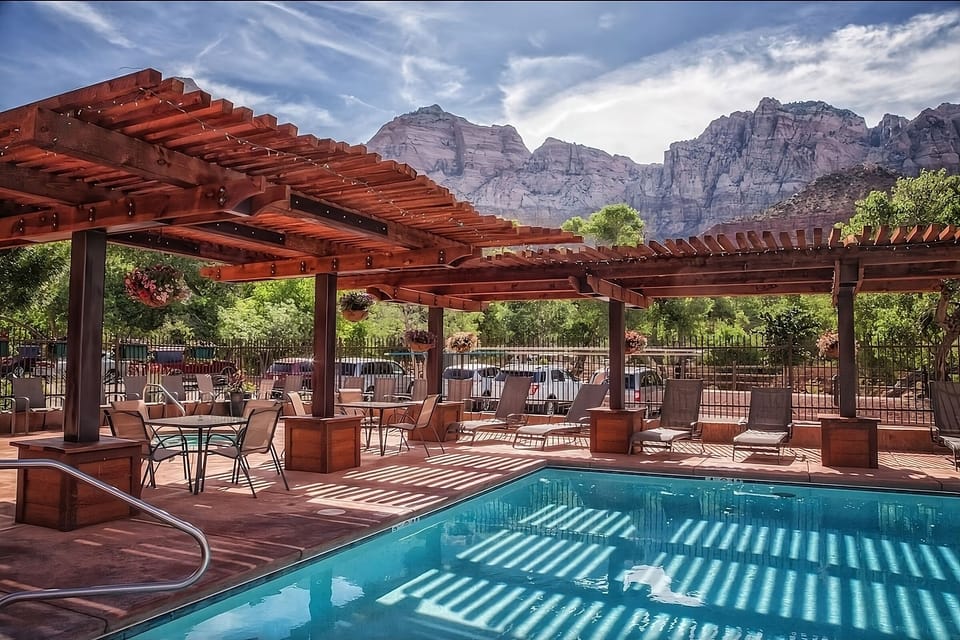 Dive into sunlit serenity beneath pergolas and mountain views.
