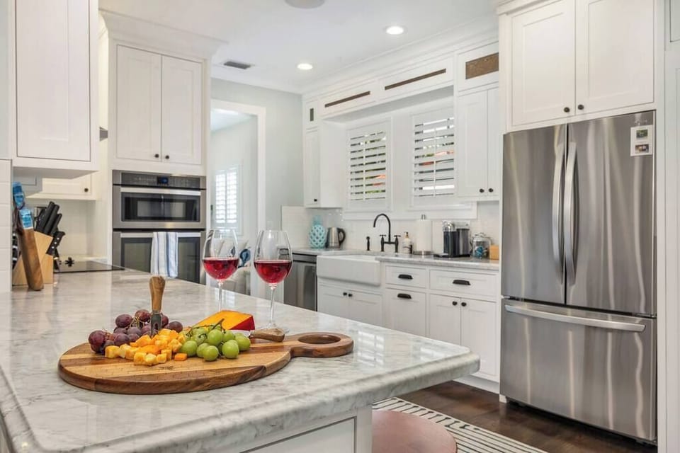 Modern kitchen with marble countertops and stainless steel appliances.