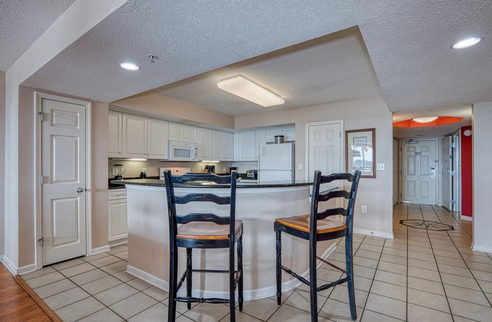 Clean and airy kitchen with granite countertops and bright lighting