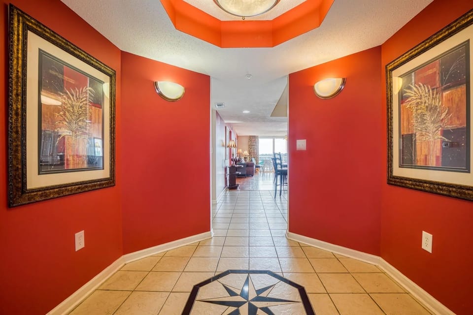 Inviting hallway with bold red walls and decorative ceiling light