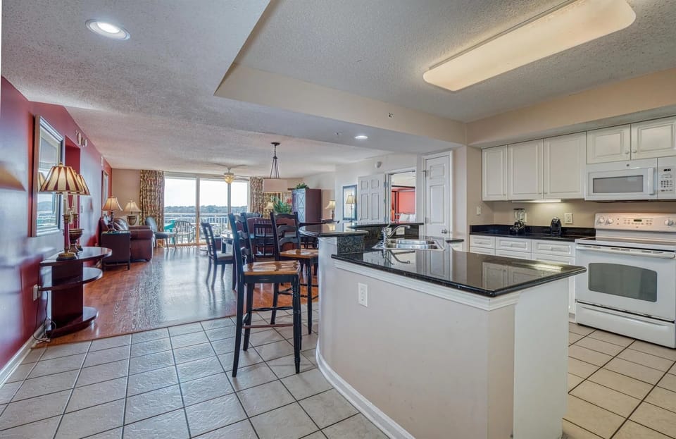  Open-concept kitchen with modern white cabinetry and bar seating