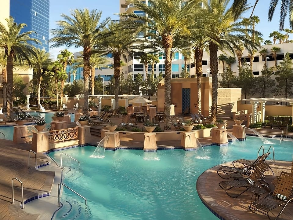 Relax poolside with palm shade and resort loungers nearby.