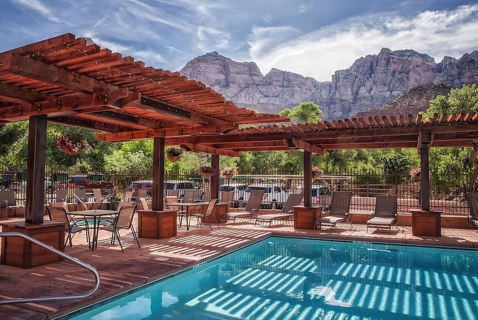 Dive into sunlit serenity beneath pergolas and mountain views.