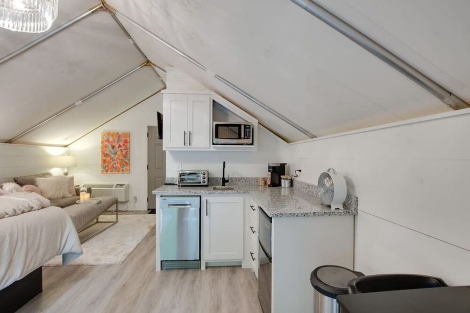 Spacious glamping tent with a complete kitchenette including a dishwasher and modern appliances, paired with a tasteful decor for a unique and enjoyable getaway