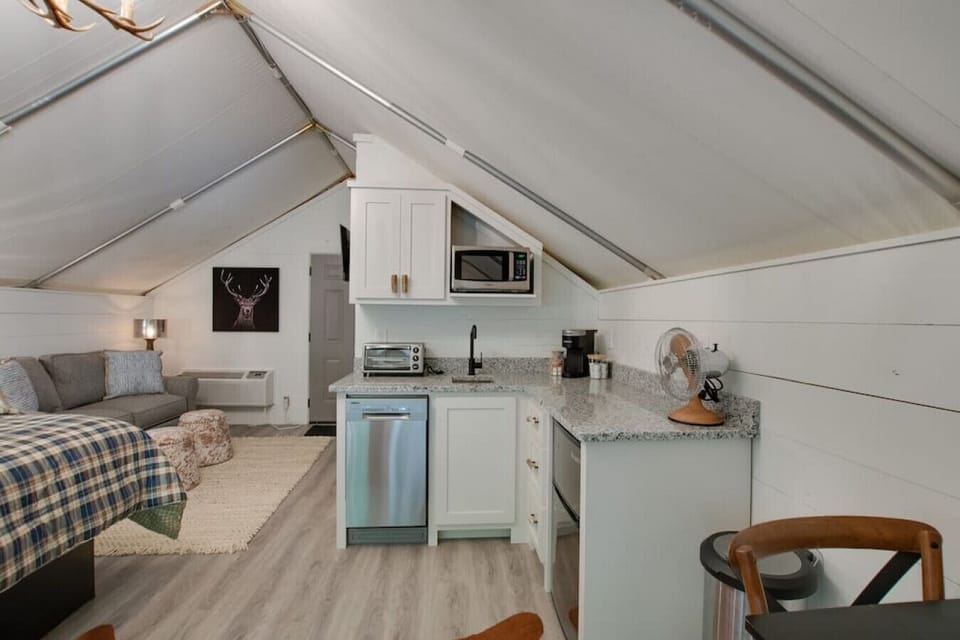 Spacious glamping tent featuring a complete kitchenette with modern appliances and tasteful décor,perfect for a comfortable and entertaining retreat