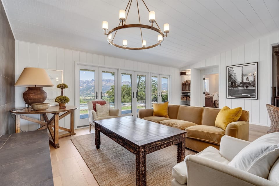 Living room with formal seating and views to the palisades and pool.