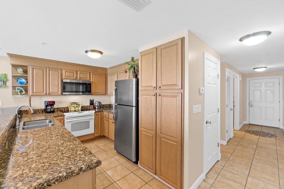 Fully stocked kitchen with spacious cabinets, granite countertop and appliances.