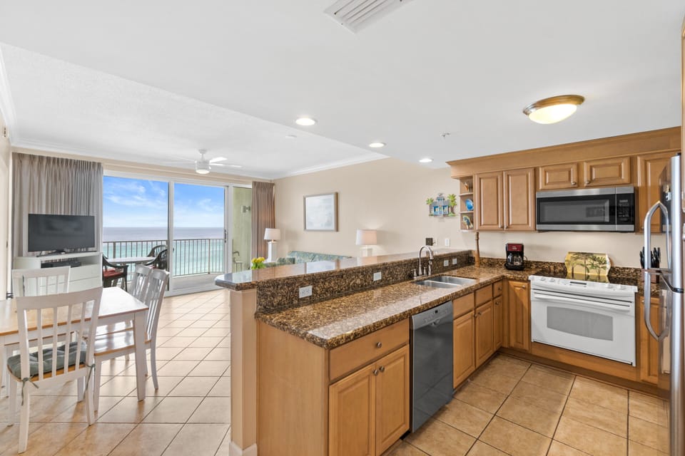 Granite countertops and warm sandy tones in the kitchen w/ view of the Gulf 