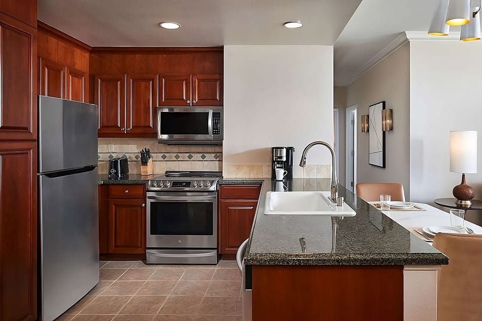 Cook with ease in a stainless kitchen and granite bar.