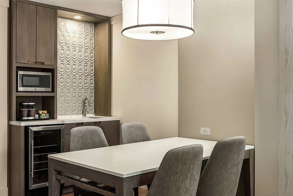 Share breakfast at the table beneath warm, modern lighting.