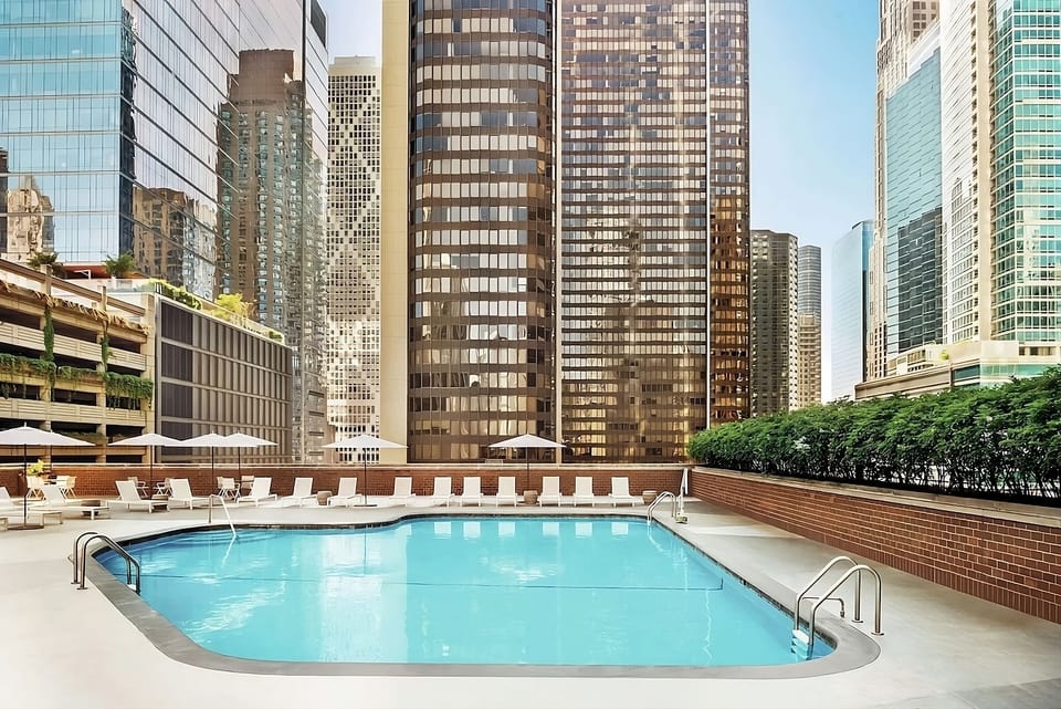 Unwind poolside amid soaring towers and open blue skies.