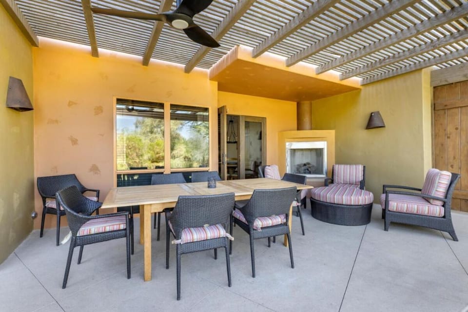 Gather for shaded patio meals beside a cozy outdoor fireplace.