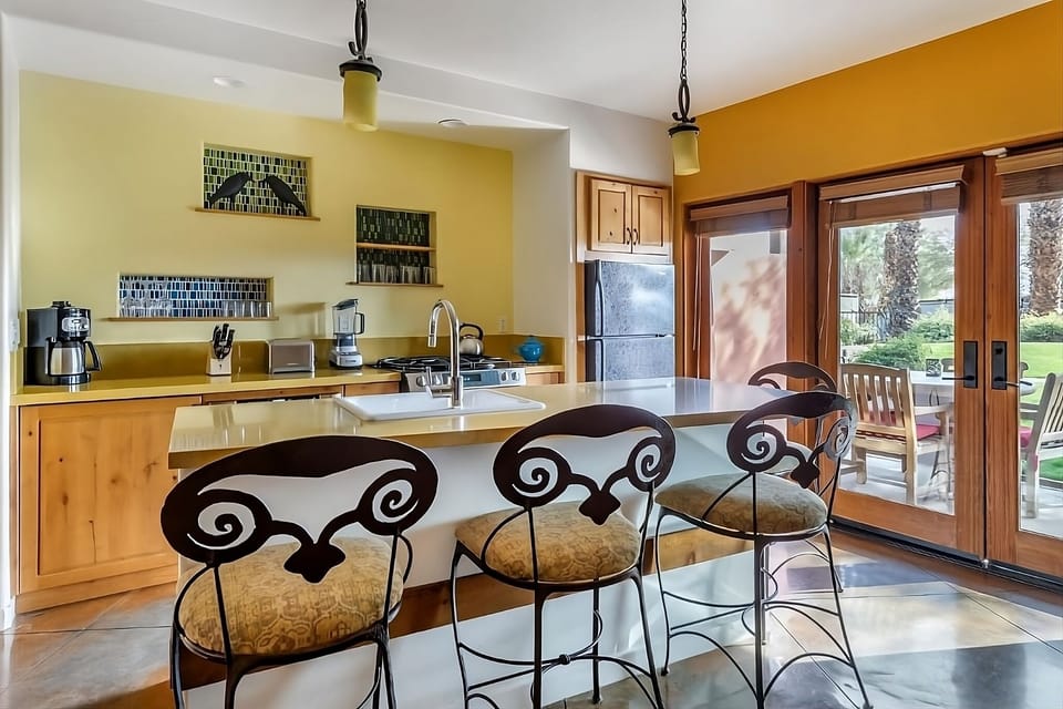 Cook together at the sunny island, steps from the patio.