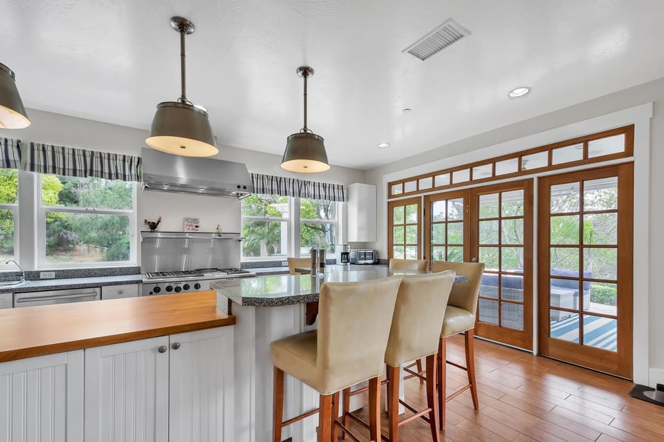 Kitchen: barstool seating, stainless steel appliances, natural lighting, two ovens, and a large refrigerator!