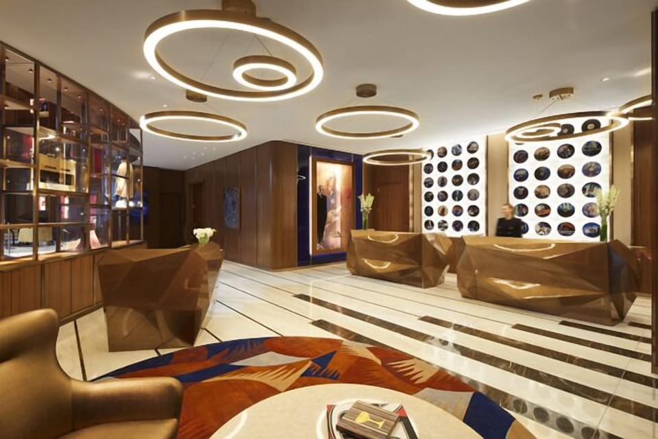 Arrive smoothly in a chic lobby with warm lighting.
