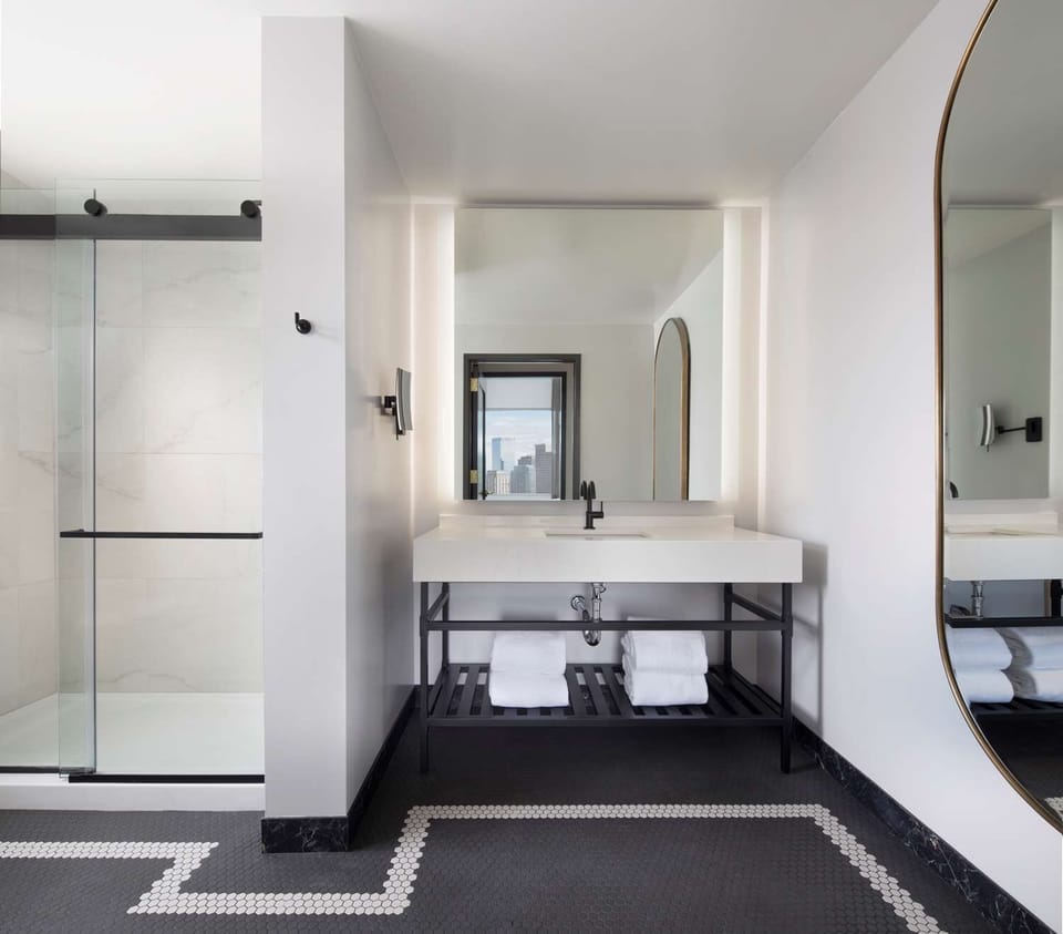 Refresh under bright vanity lights in a sleek spa bath.