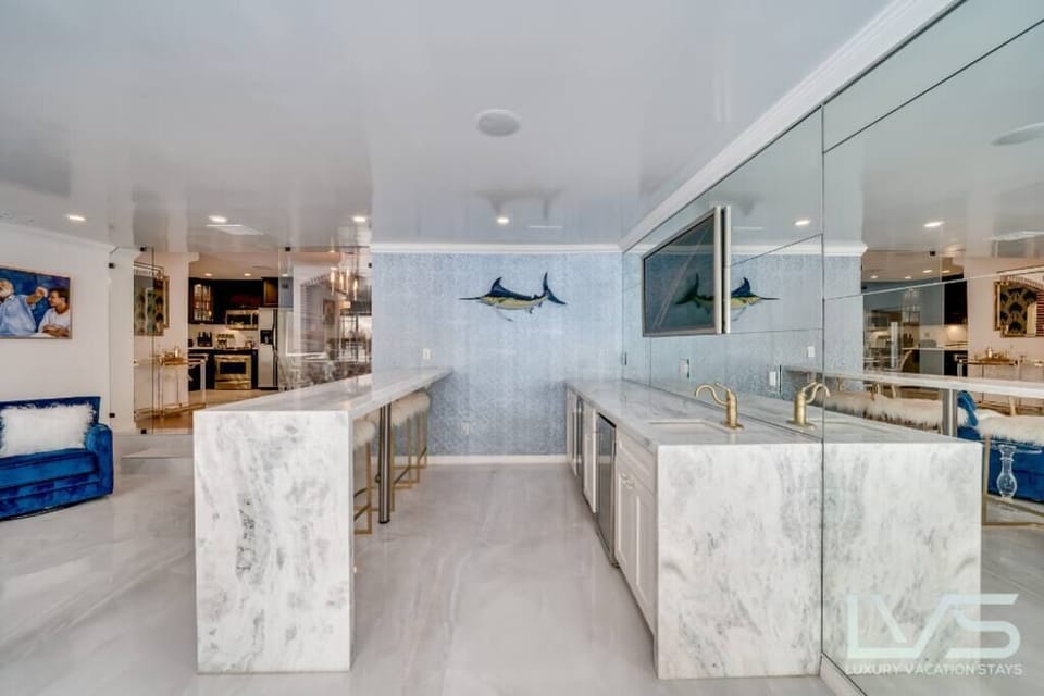 Living room with bar, ice maker, wine cooler & custom framed 70” Smart TV.