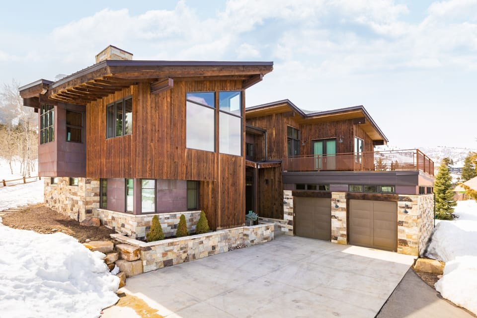 - Modern mountain home with striking wood and stone design  - Expansive windows showcase natural surroundings  - Spacious driveway with easy access to mountain adventures