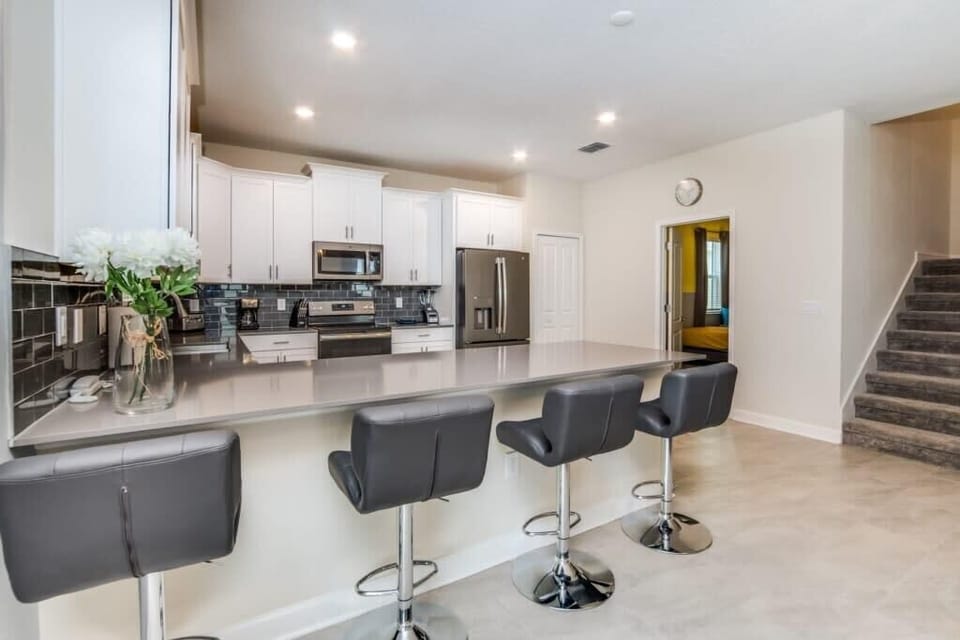 The fully equipped open-concept kitchen features stainless steel appliances, ample counter space, and everything you need to prepare and enjoy family meals during your vacation.