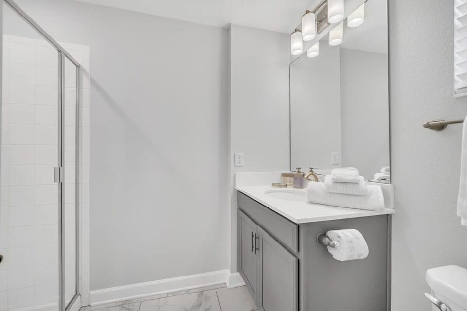 Bright full bathroom featuring a single vanity, shower, and modern finishes for a comfortable and refreshing experience.