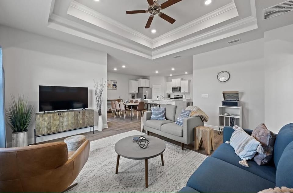 Unwind in your spacious living room with plush seating, modern entertainment, and an elegant coffered ceiling.