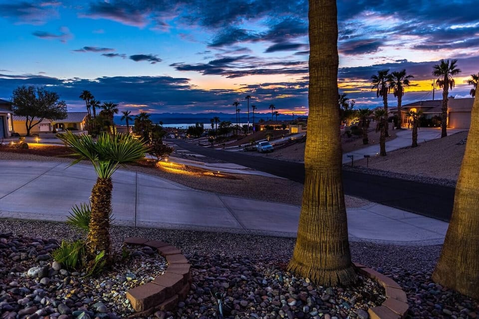 Step to the water's edge and Lake Havasu is right here — palm trees, shoreline, mountains catching the last light of day.