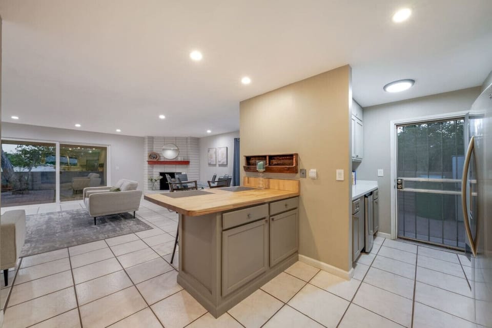 Views of the grand living room, kitchen peninsula, and coffee bar