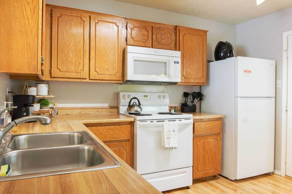 Kitchen is well stocked with dishware and cookware. 