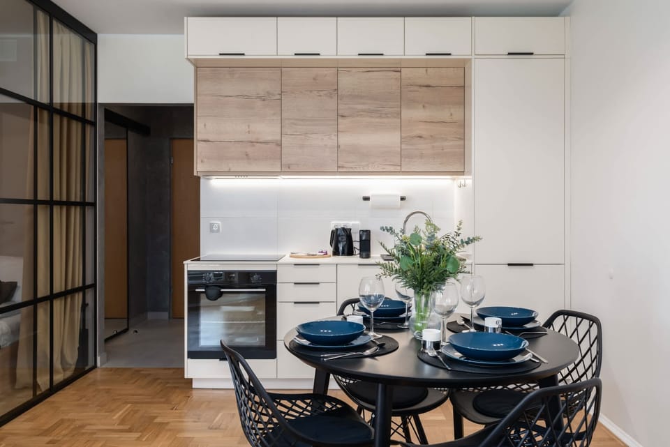 A dining area connected to a modern kitchen with light wooden cabinets.