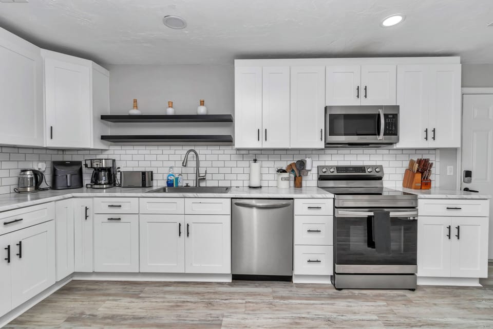 Upgraded kitchen, wine/coffee nook, recessed lights, newer appliances, pots/pans