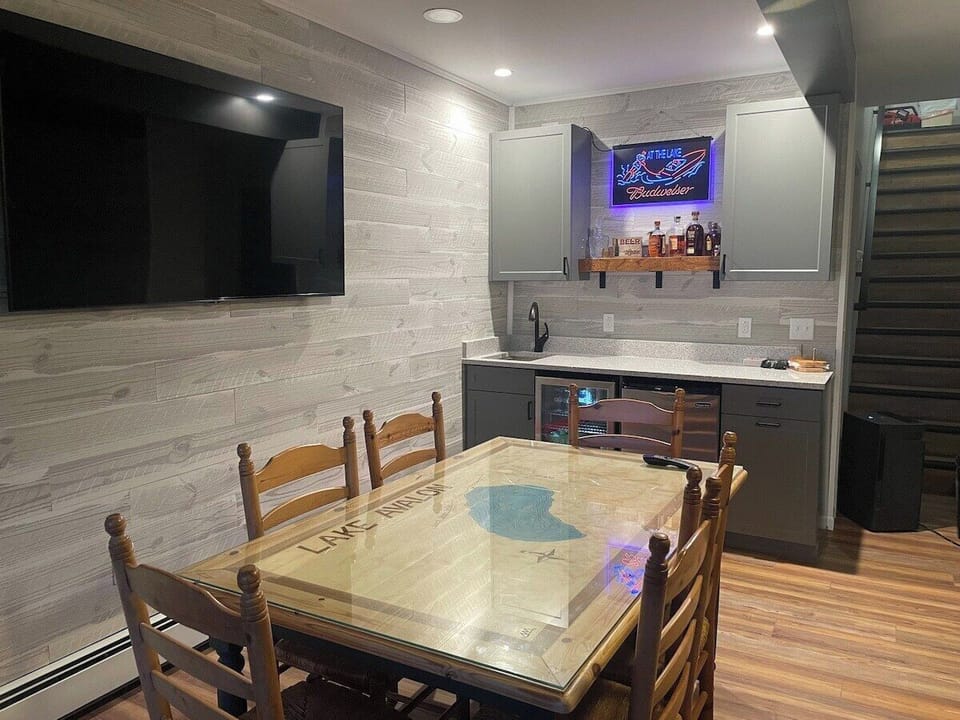 The wet bar has a sink, beverage fridge, freezer, and plenty of glassware. 