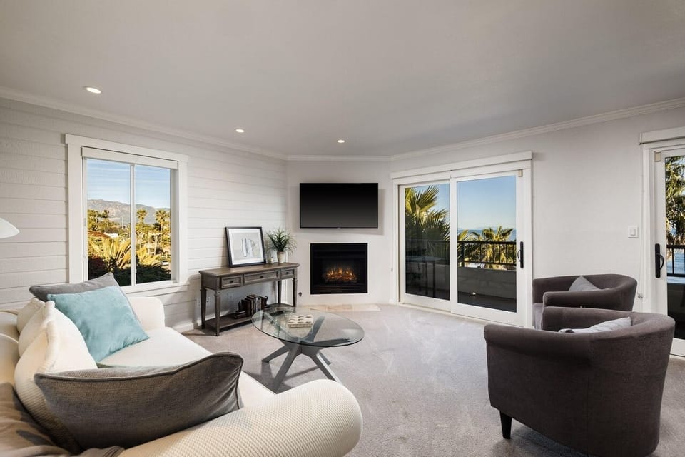 Spacious Living Room with Balcony access~ a fireplace~ and TV.