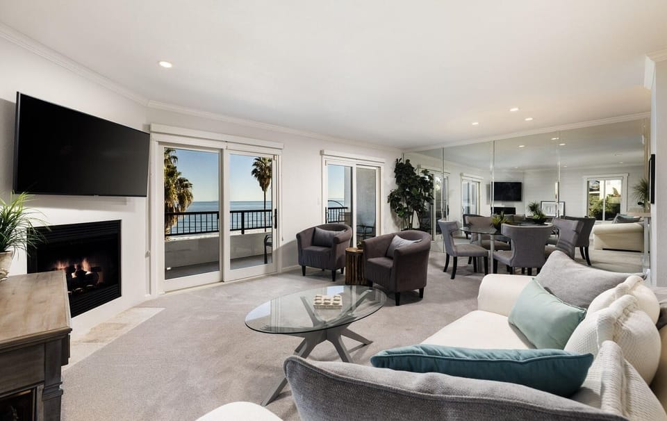 Spacious Living Room with Balcony access~ a fireplace~ and TV.