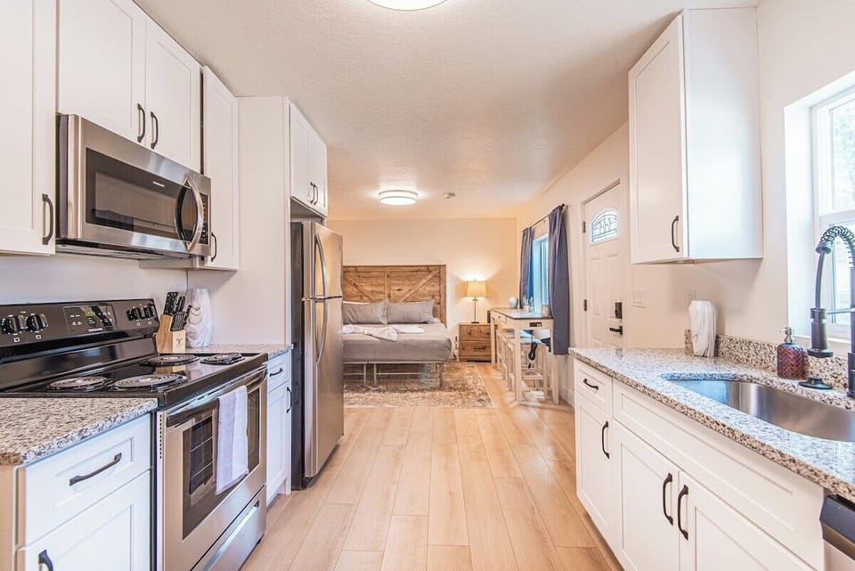 Full kitchen with white cabinetry, stainless steel appliances, and modern finishes throughout.