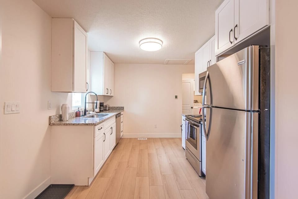 Kitchen layout showing sink, appliances, and white cabinetry organization.