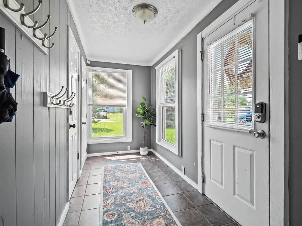 Step into a bright and welcoming entryway with large windows, cheerful décor, and plenty of hooks for coats and bags  A charming first impression that sets the tone for your cozy stay! 