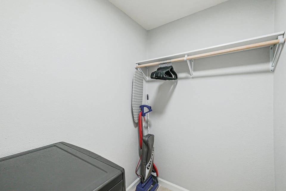 Bedroom walking closet with washer and dryer combo. We provide laundry soap, cleaning supplies, vacuum, ironing board, and iron.