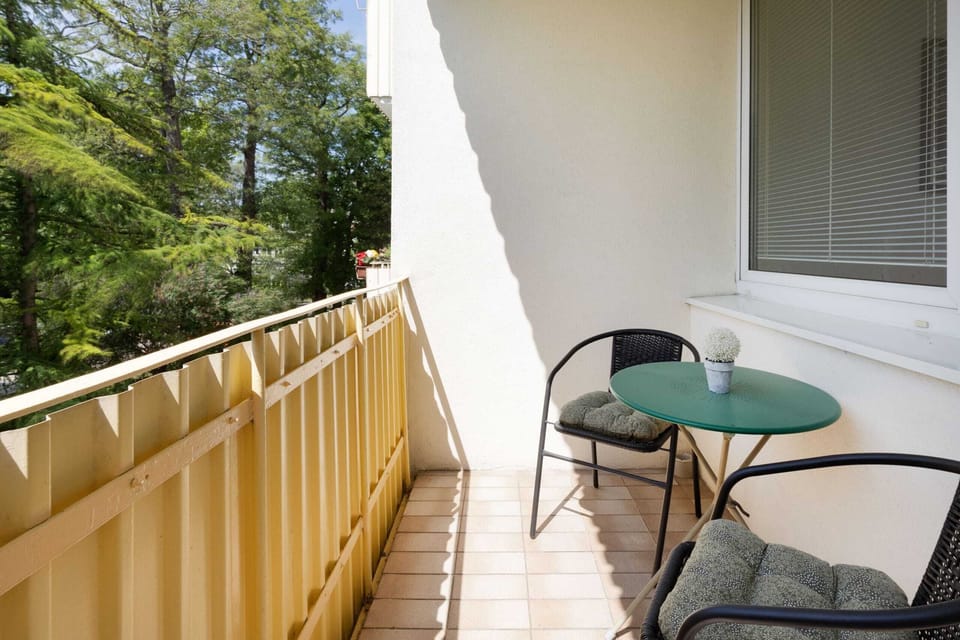 Furnished balcony with green surroundings. 