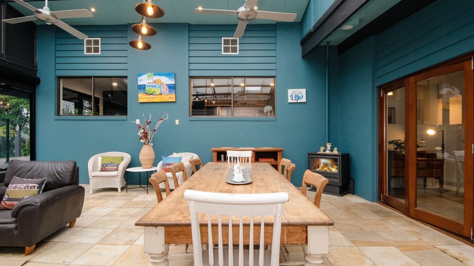The long formal dining table, nestled beside an inviting wood-burning fireplace. 