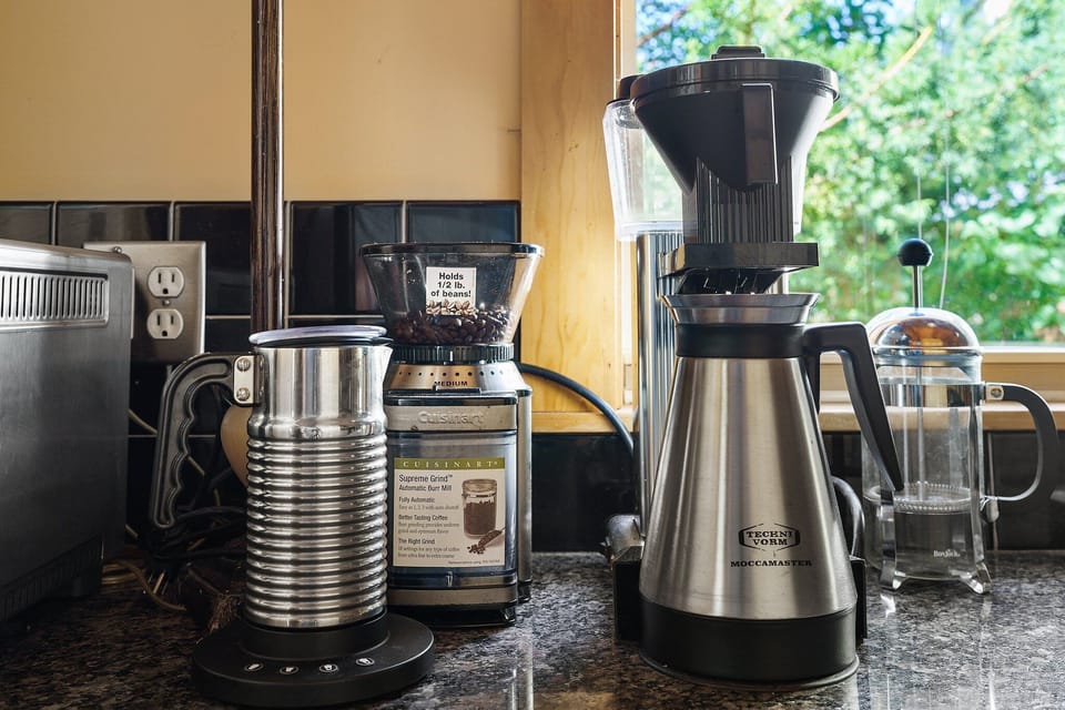 Wake up to your perfect cup with premium coffee equipment ready for your morning ritual in this well-appointed kitchen.