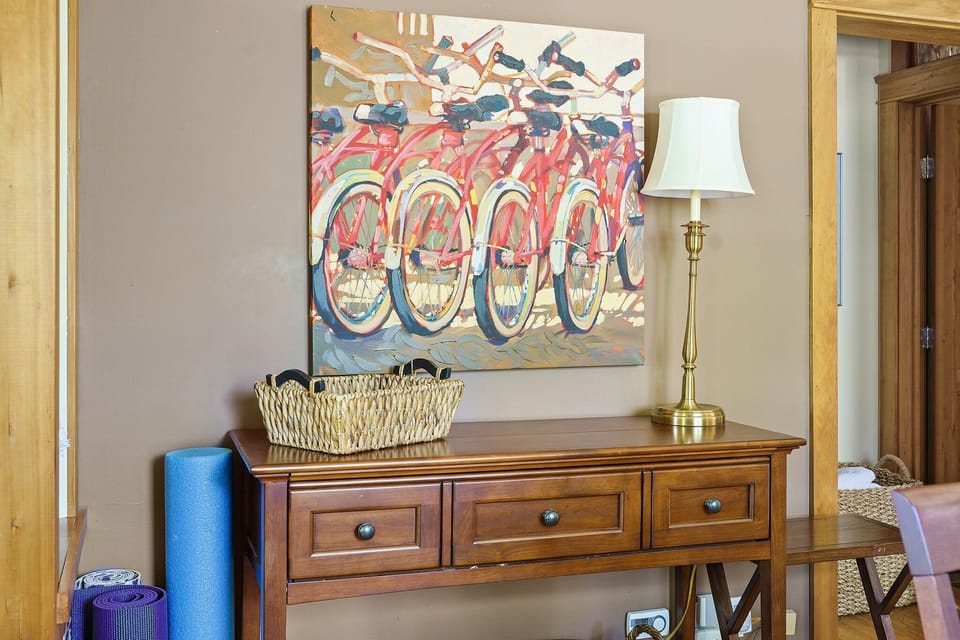 Unwind in this thoughtfully designed space where colorful bicycle art adds charm to your warm wooden furnishings.