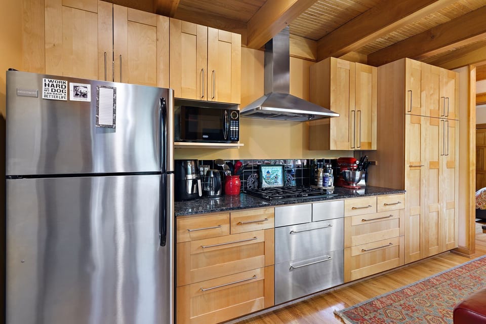 Your fully equipped kitchen features stainless steel appliances and warm wood cabinetry, perfect for preparing memorable meals during your stay.