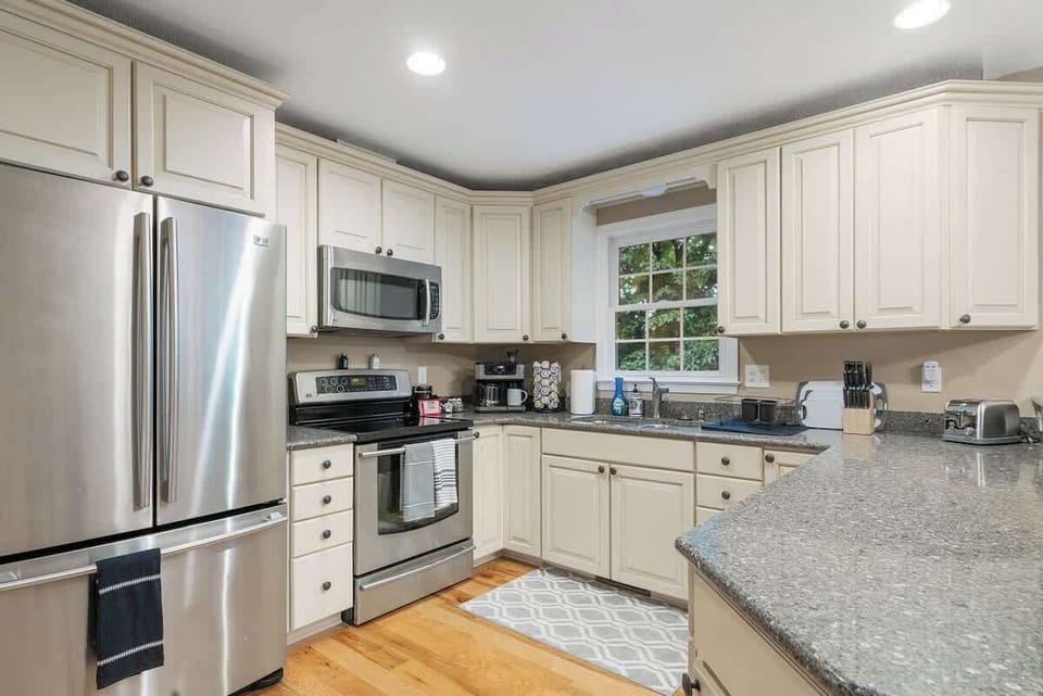 Fully stocked kitchen: pots, pans, utensils, and a coffee bar with K-cups, ground coffee, creamer, sugar, and tea.