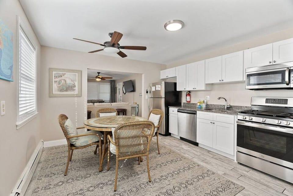 This sleek and modern kitchen is fully equipped with everything you need to cook up a delicious meal. The stainless steel appliances and marble countertops create a luxurious feel, while the white cabinets add a touch of comfort.